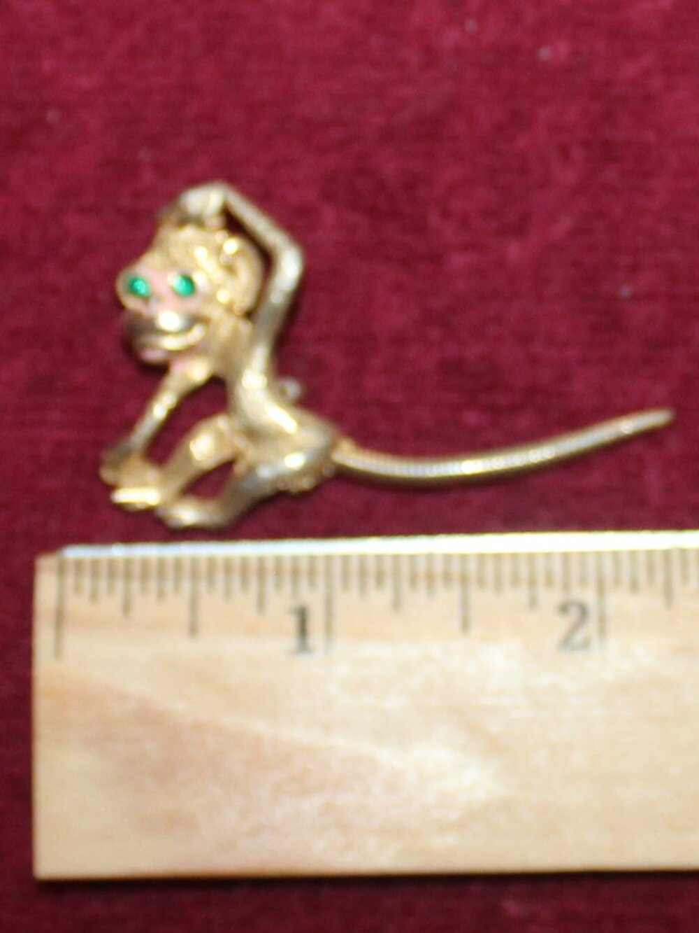 Vintage gold-tone monkey brooch features a movable tail and green rhinestone eye